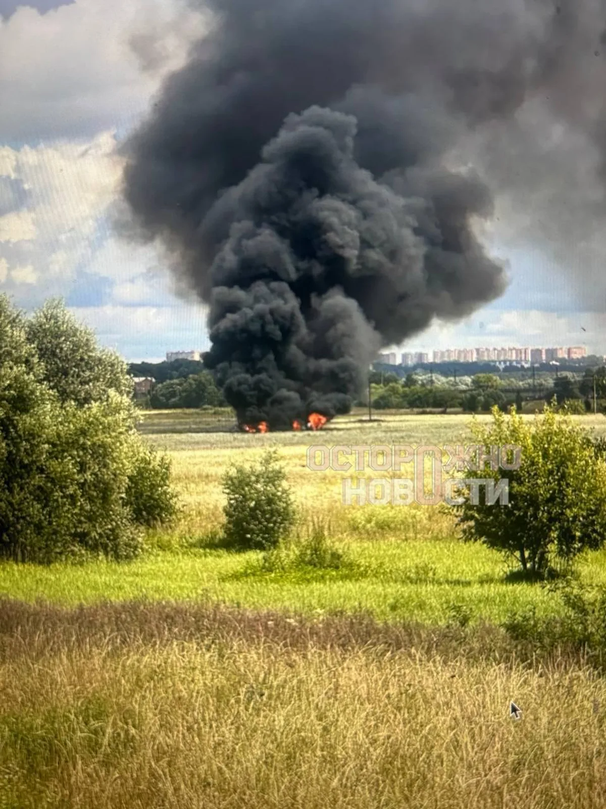 Чорний дим від пожежі в полі біля міста