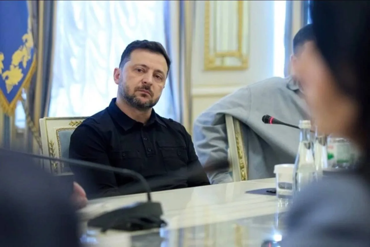 Чоловік у чорній сорочці на офіційній зустрічі за столом