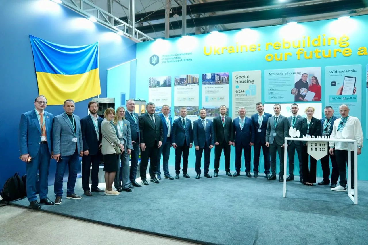 Група чиновників на виставці з українським прапором