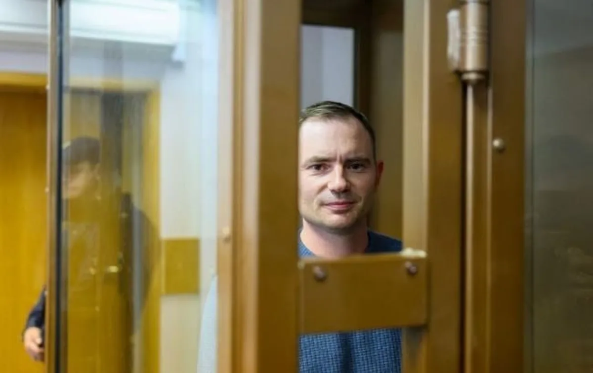 Чоловік за скляною перегородкою в залі суду