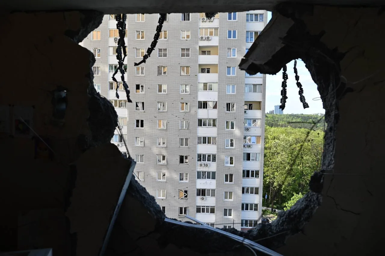 Вид на багатоповерховий будинок крізь отвір у стіні