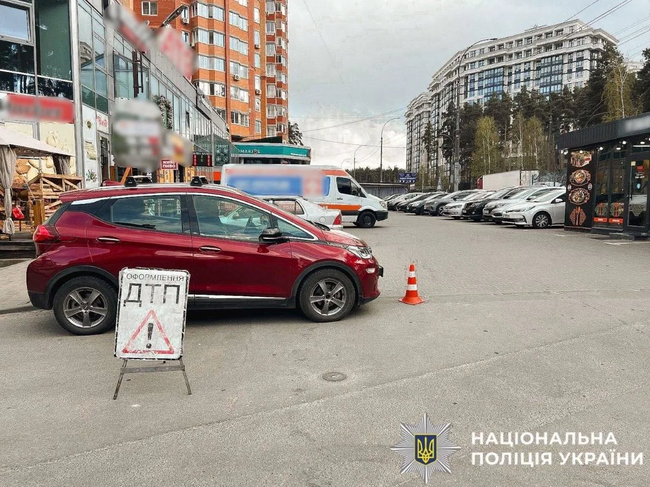 Місце дорожної аварії з пошкодженим червоним автомобілем на паркінгу