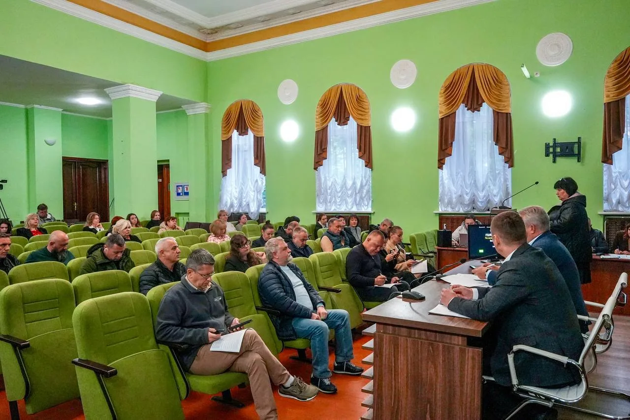 Засідання в залі з зеленими стінами та яскравими креслами