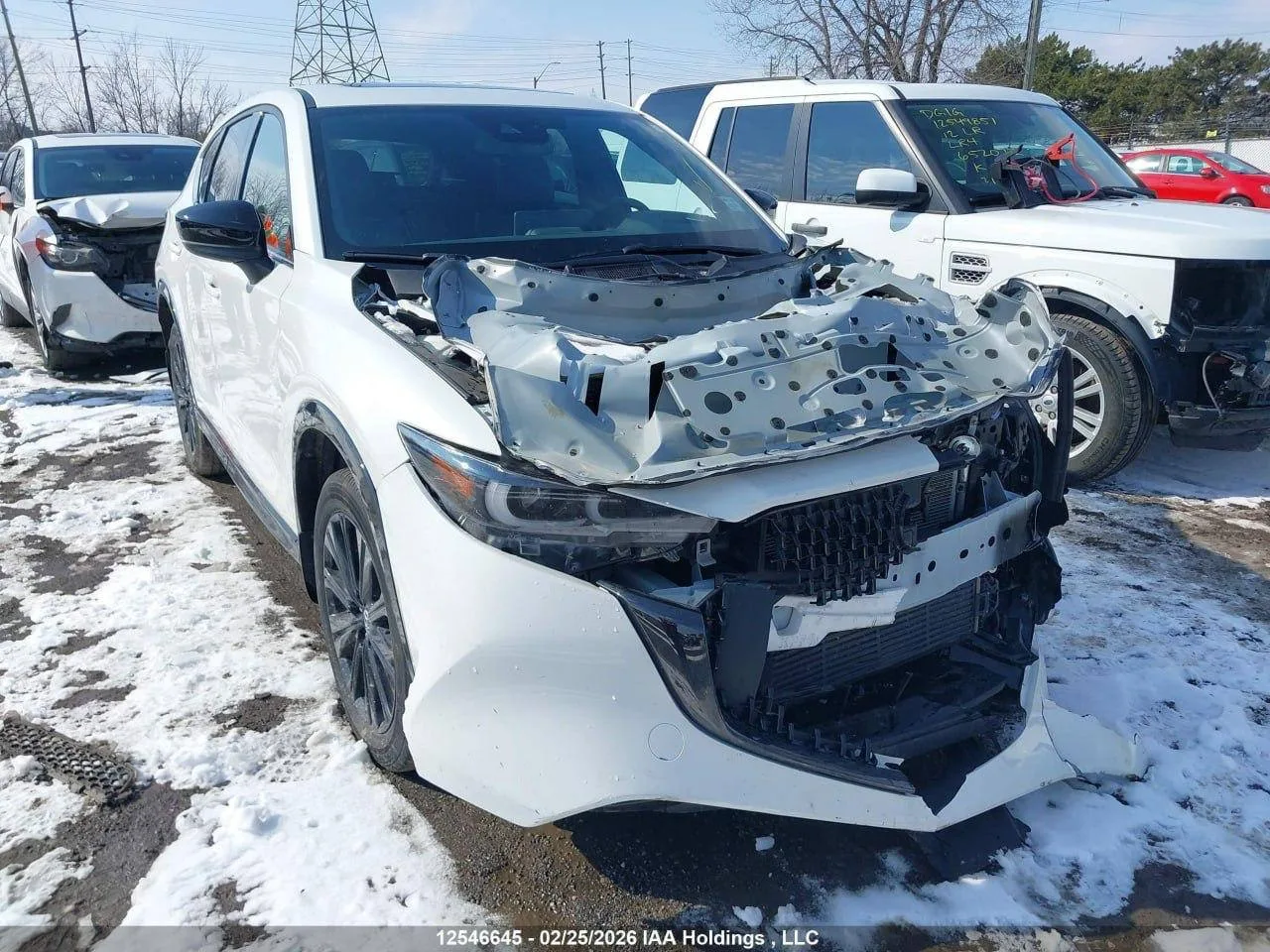 Пошкоджений білий автомобіль на стоянці зі снігом