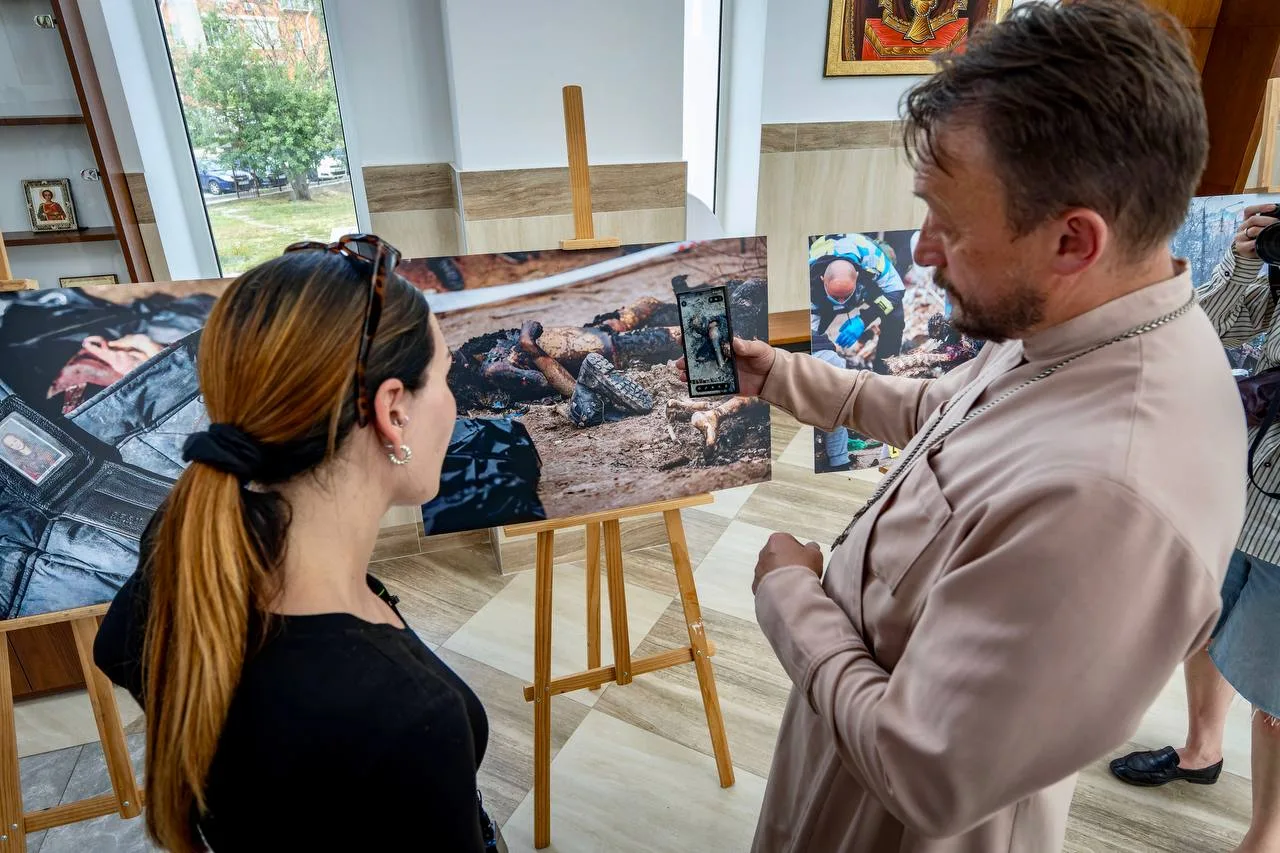 Чоловік та жінка розглядають фотографії на виставці в приміщенні