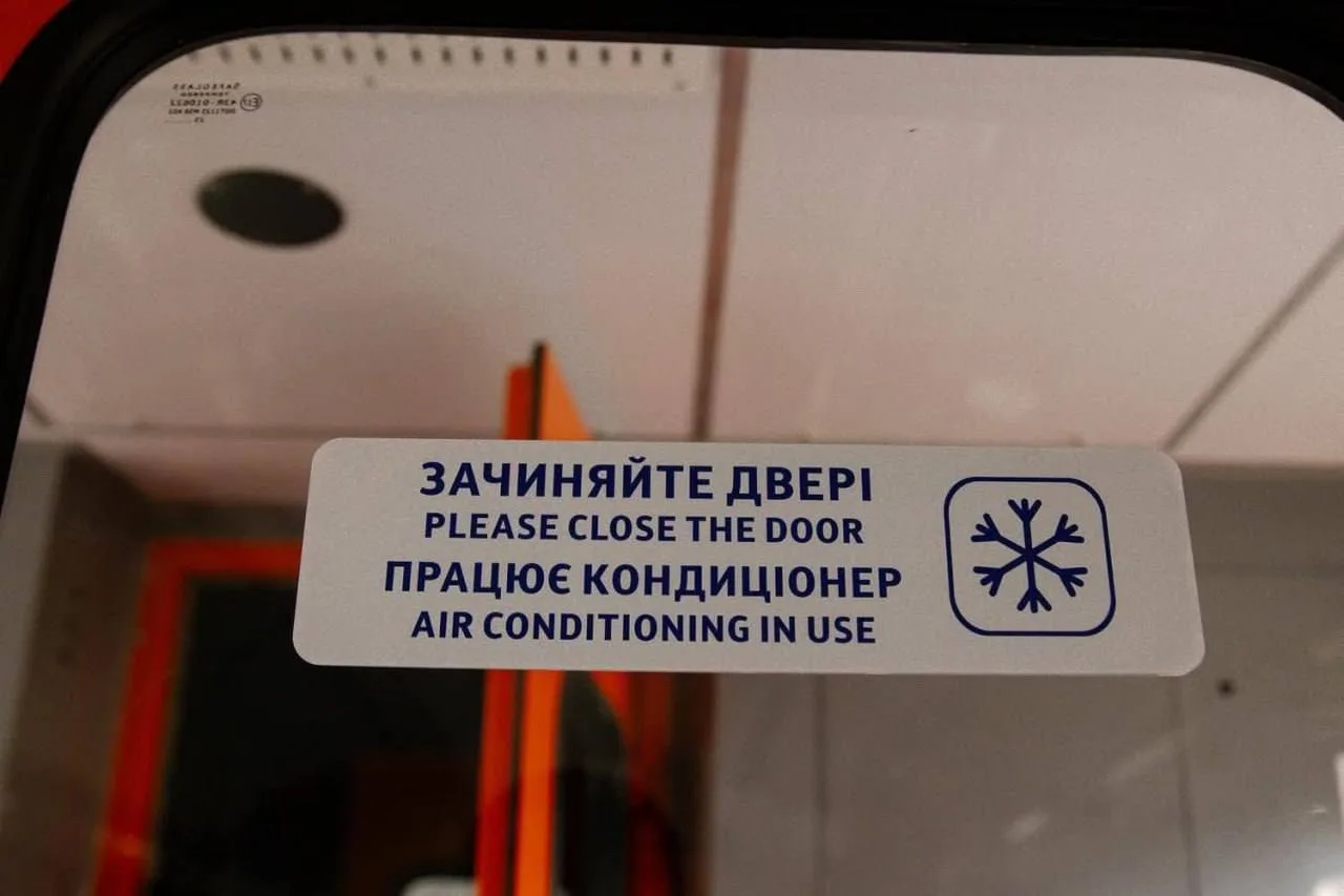 Табличка на дверях вагона з написом про закриття дверей та кондиціонування