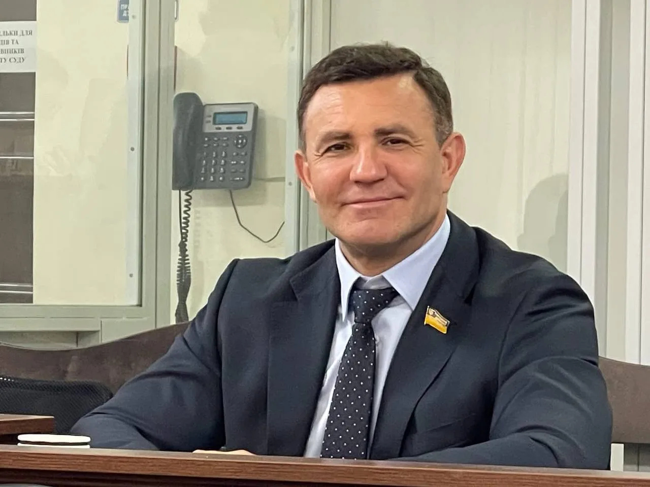 Чоловік у темному костюмі в офісному приміщенні
