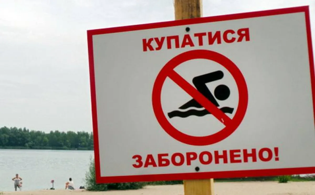 Табличка заборони купання біля водойми з червоним хрестиком