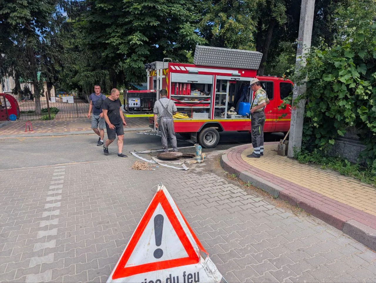Аварійна машина та робітники на місці пошкодження водогону
