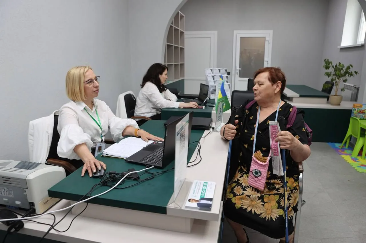 Жінки спілкуються в офісному приміщенні біля столів