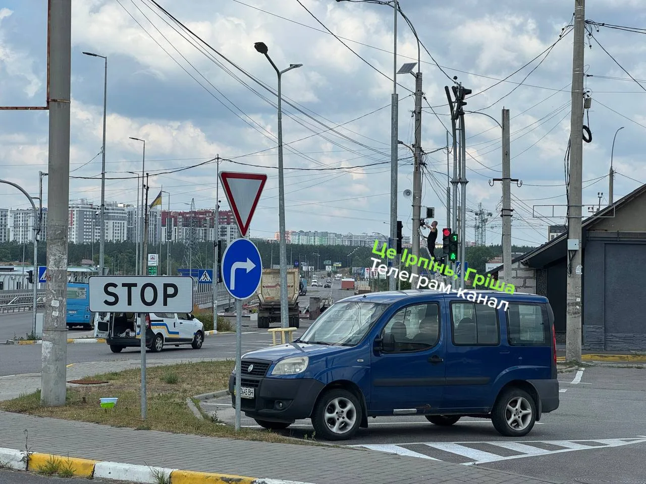 Синій мікроавтобус на перехресті з дорожними знаками