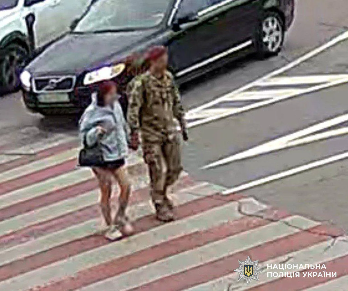 Військовий та дівчина переходять дорогу на пішохідному переході