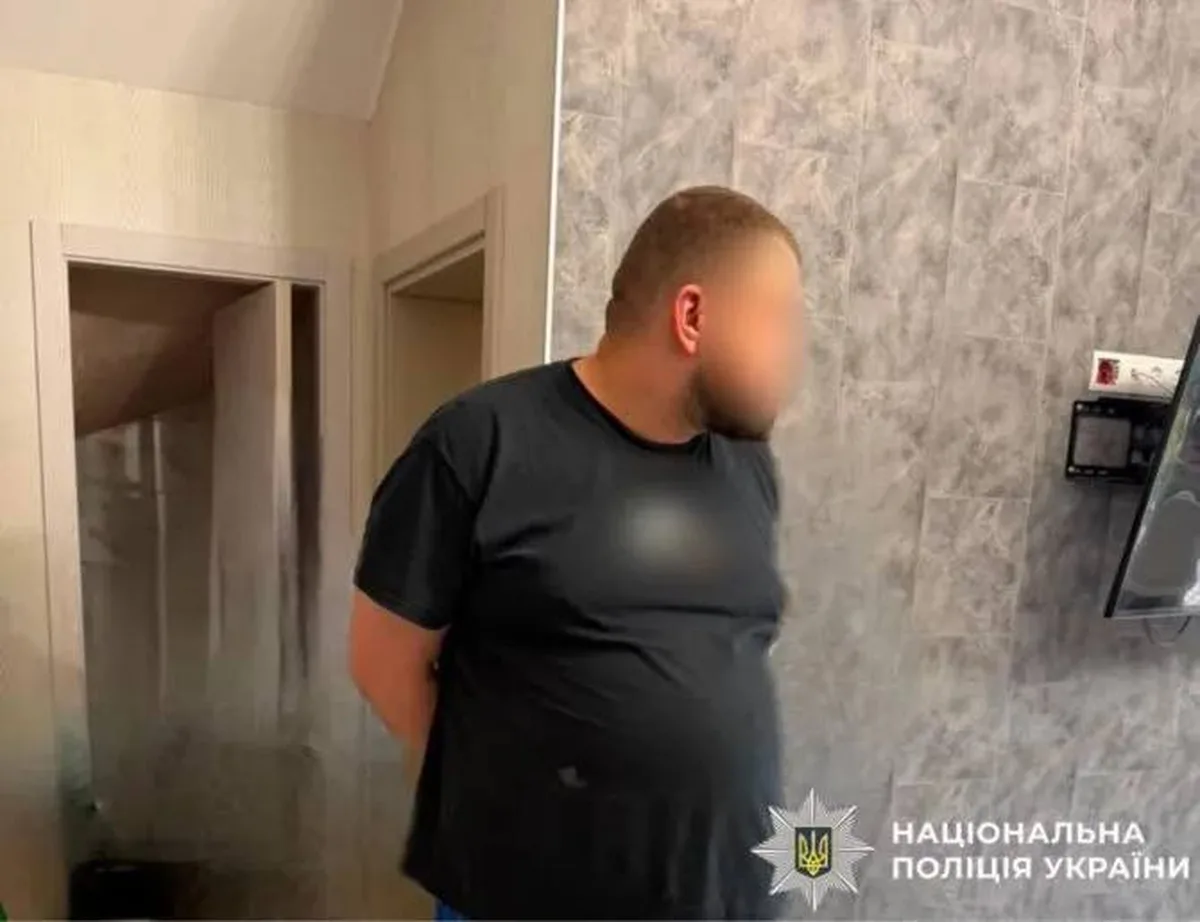 Чоловік у чорній футболці в квартирі під час поліцейської операції