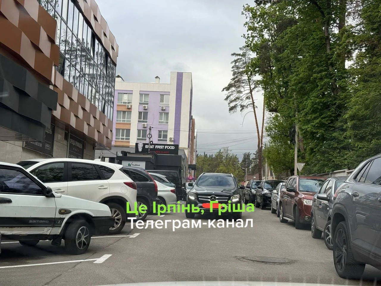 Припаркована автомобілі на вулиці біля будинків Ірпеня