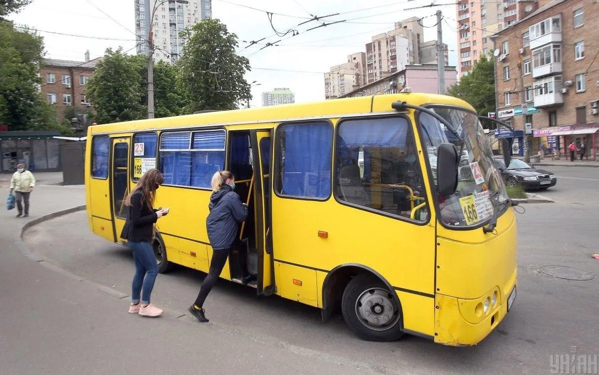 Жовтий маршрутний автобус на міській вулиці з пасажирами