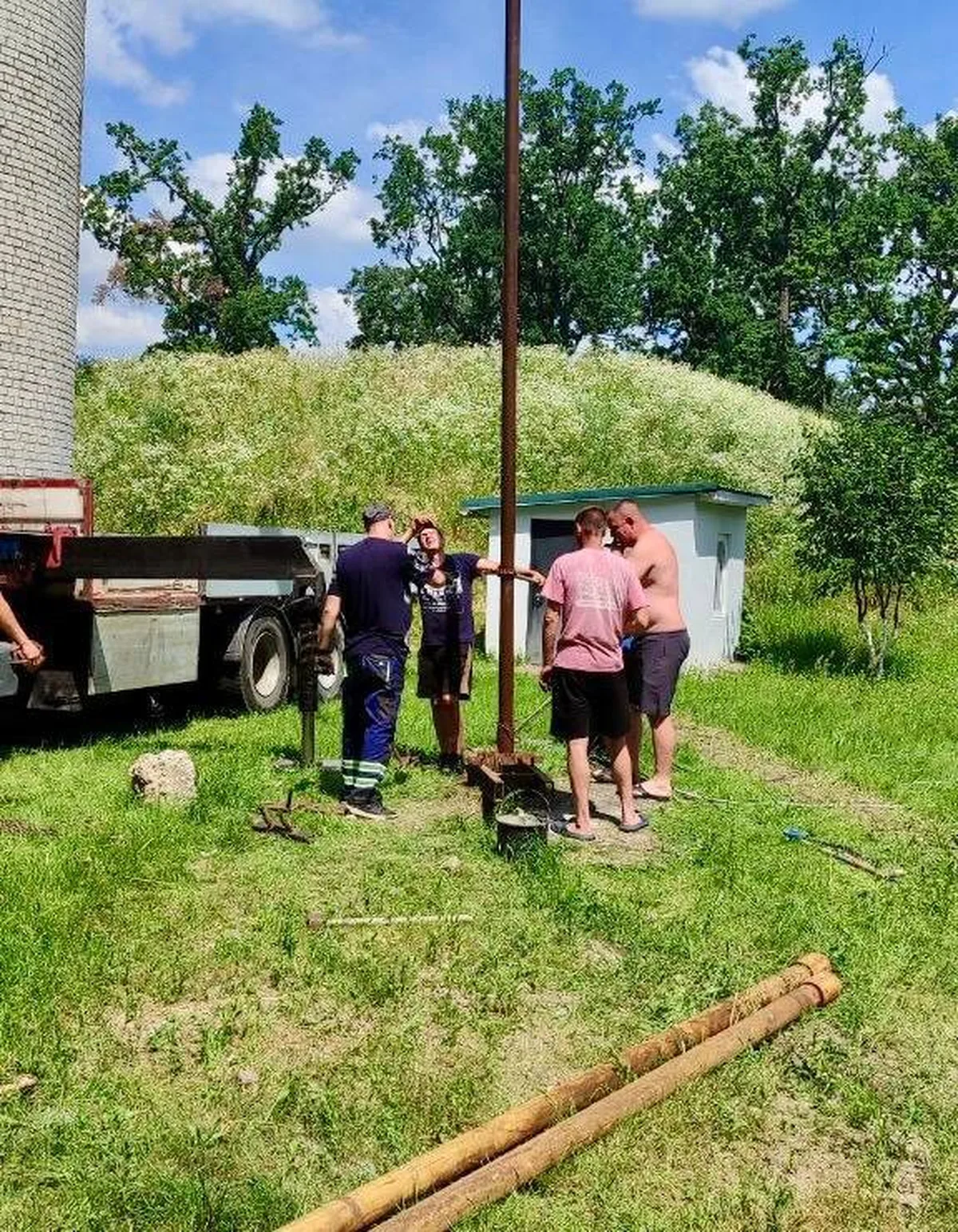 Робітники біля пошкодженої електроопори на території приватного будинку