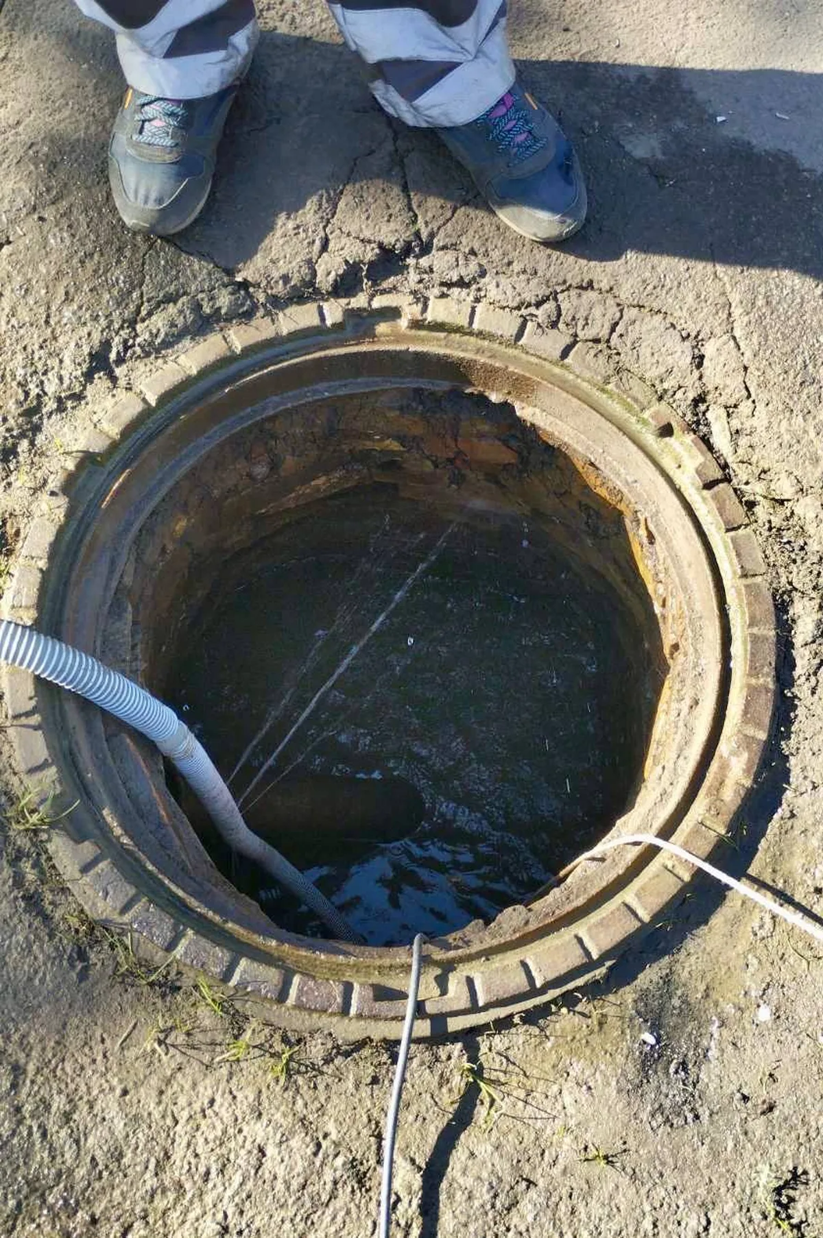 Відкритий люк водопровідної системи з пошкодженням