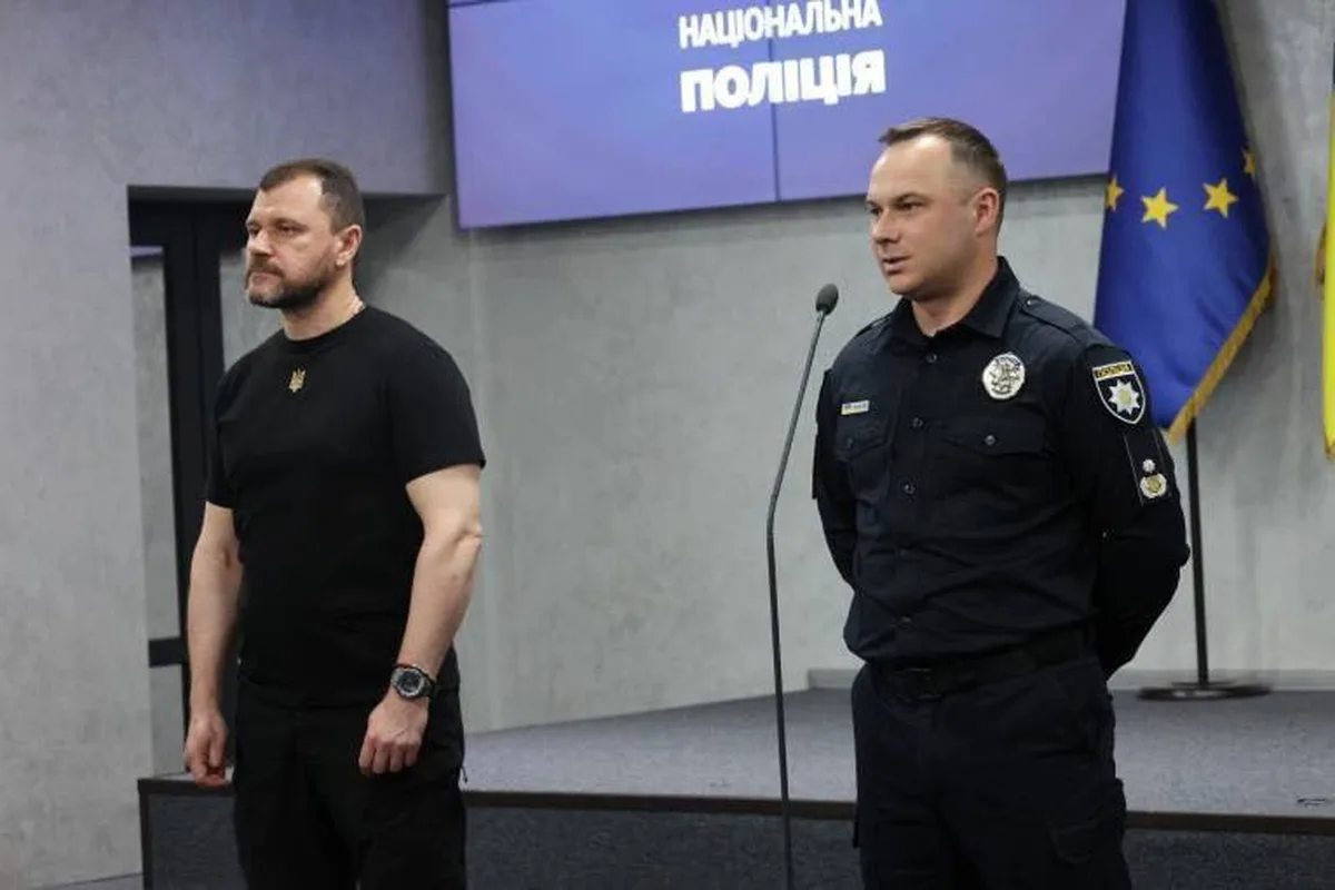 Двоє чоловіків на прес-конференції біля прапорів