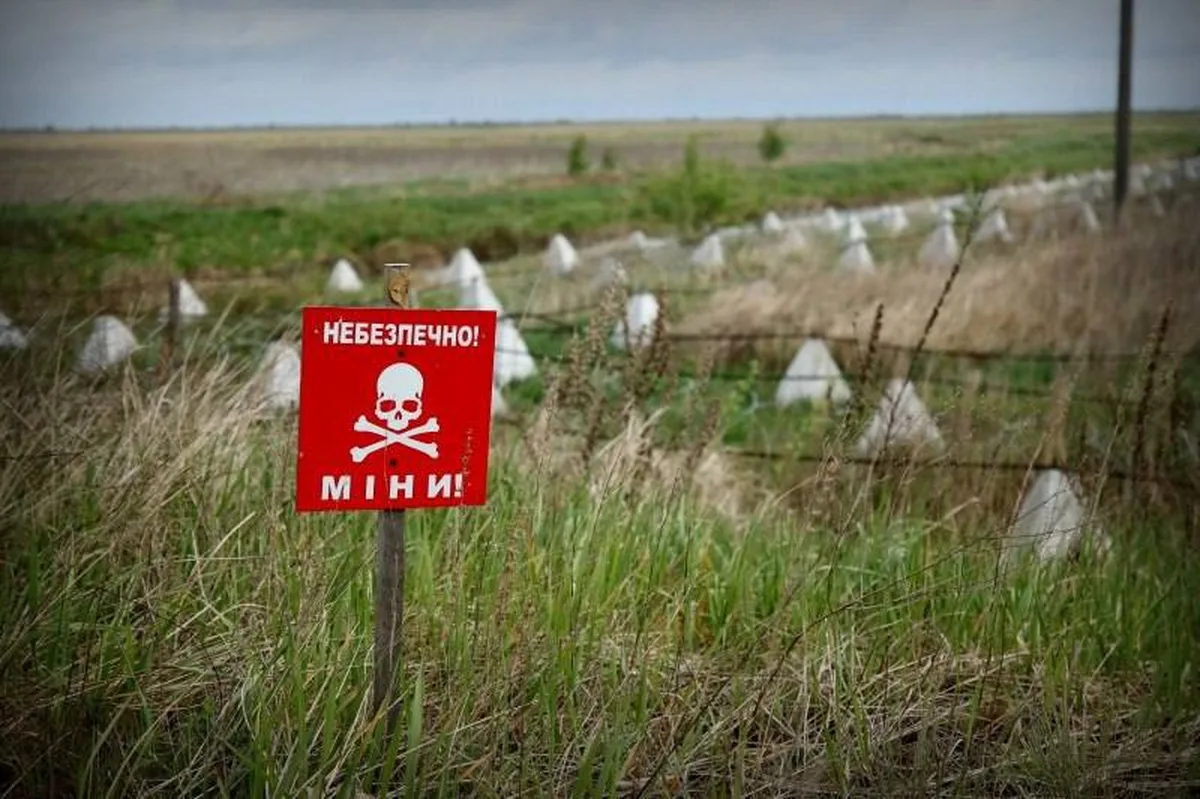 Червоний знак небезпеки мін на полі