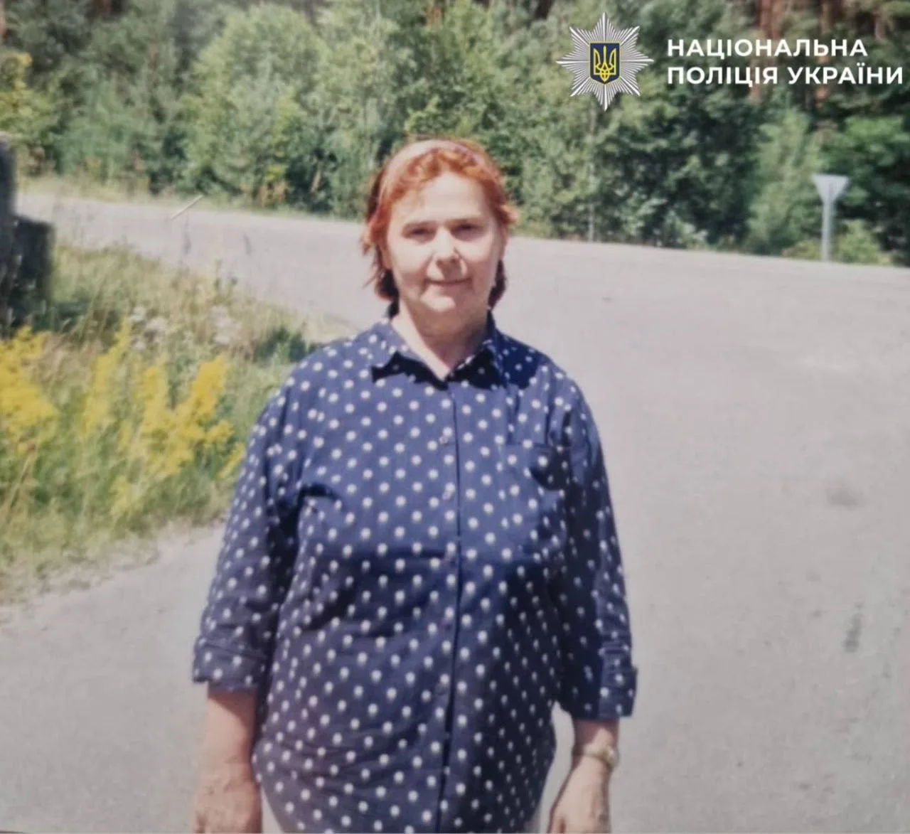 Жінка середнього віку з рудим волоссям на дорозі