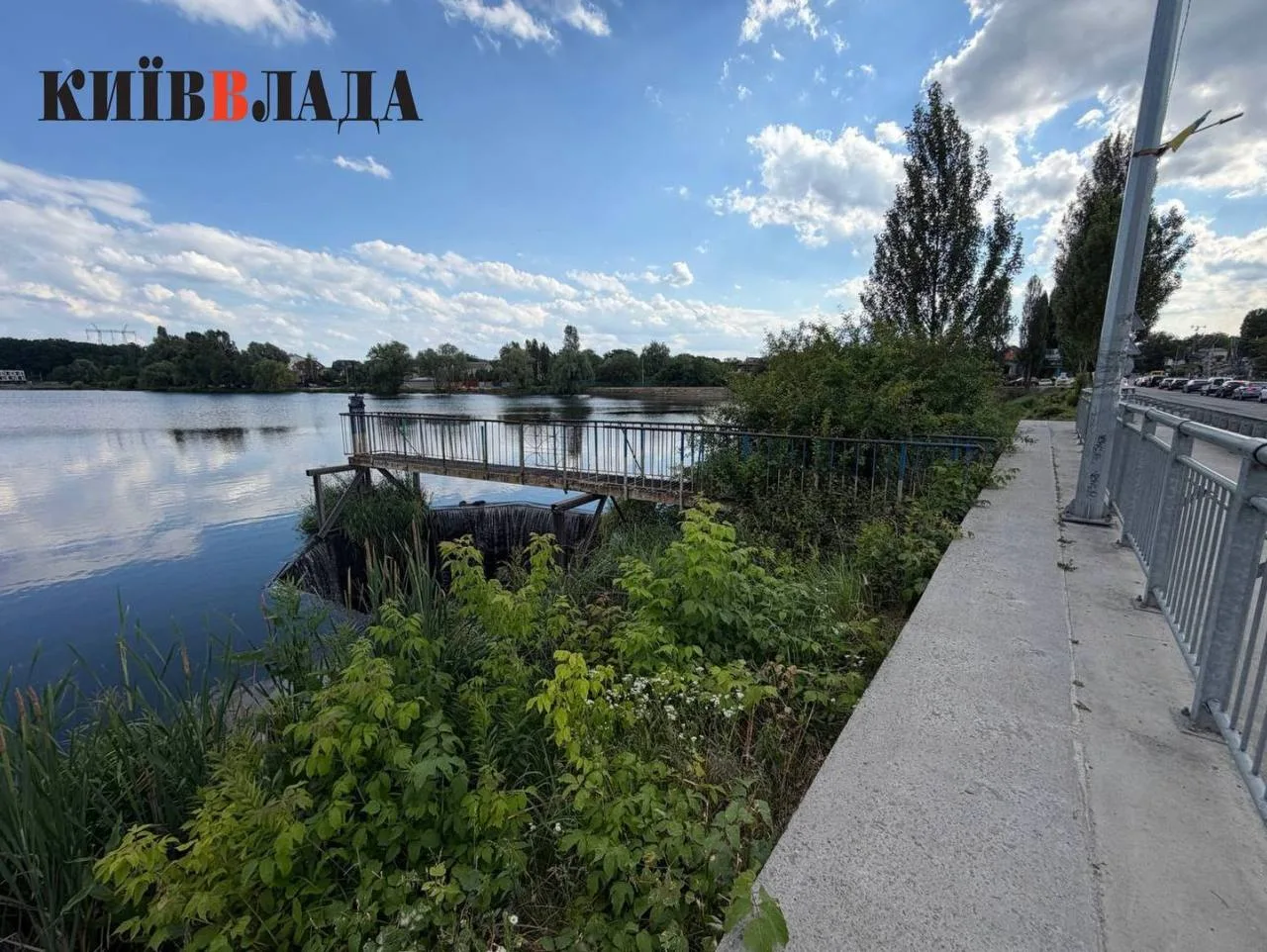 Пішохідна доріжка вздовж озера з металевим парканом