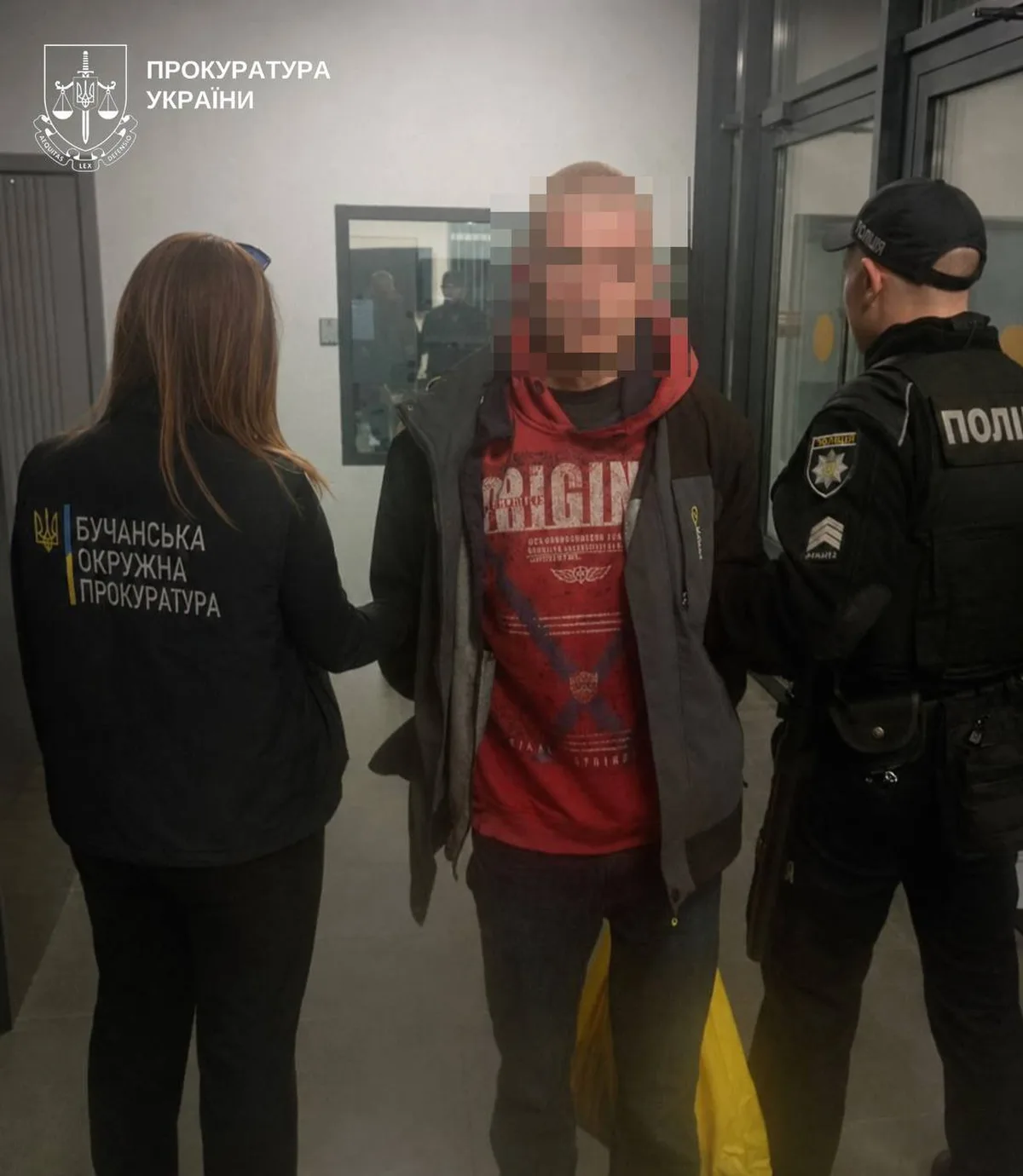 Чоловік у червоній сорочці з правоохоронцями та прокурором