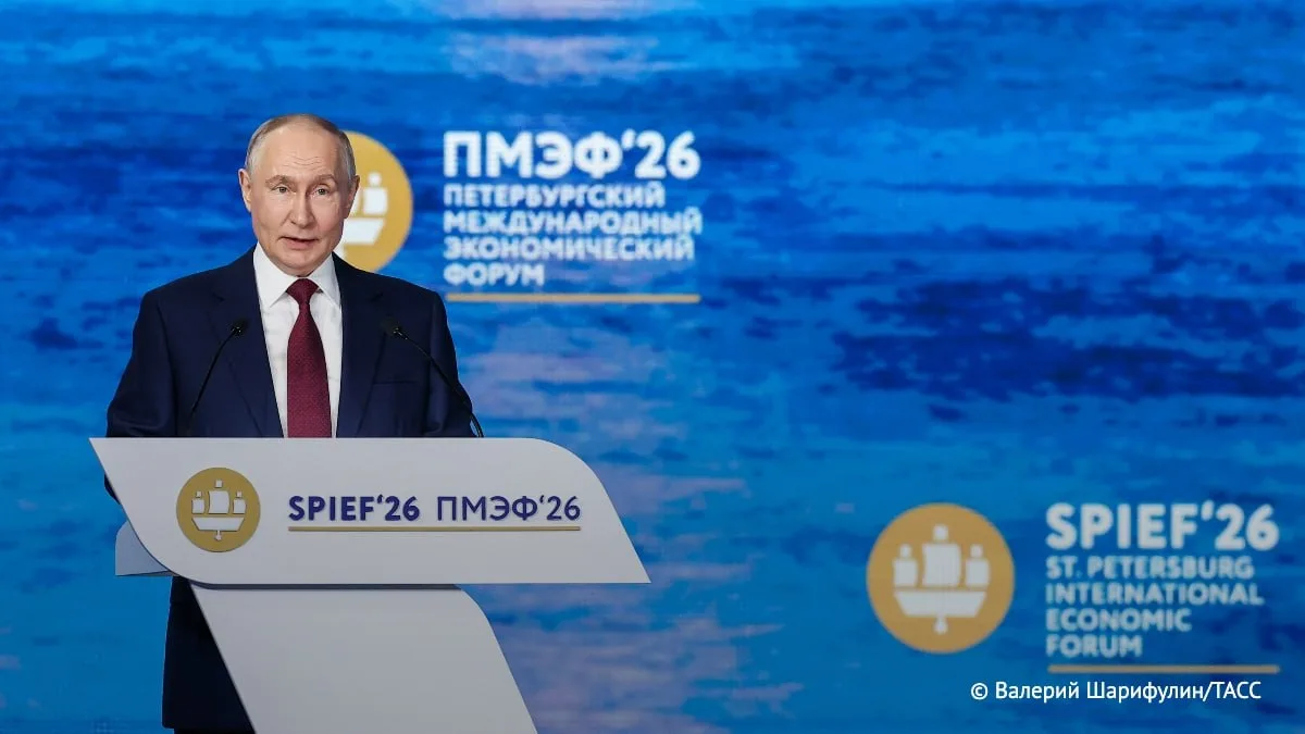 Чоловік у костюмі біля трибуни на форумі