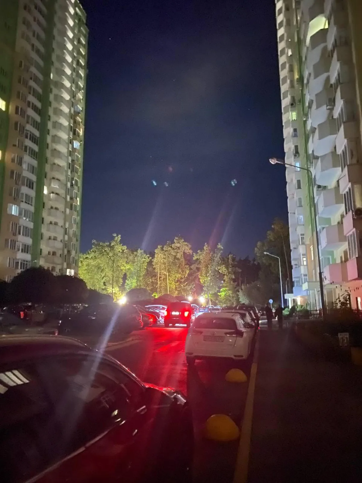 Нічна вулиця між багатоповерховими будинками без освітлення