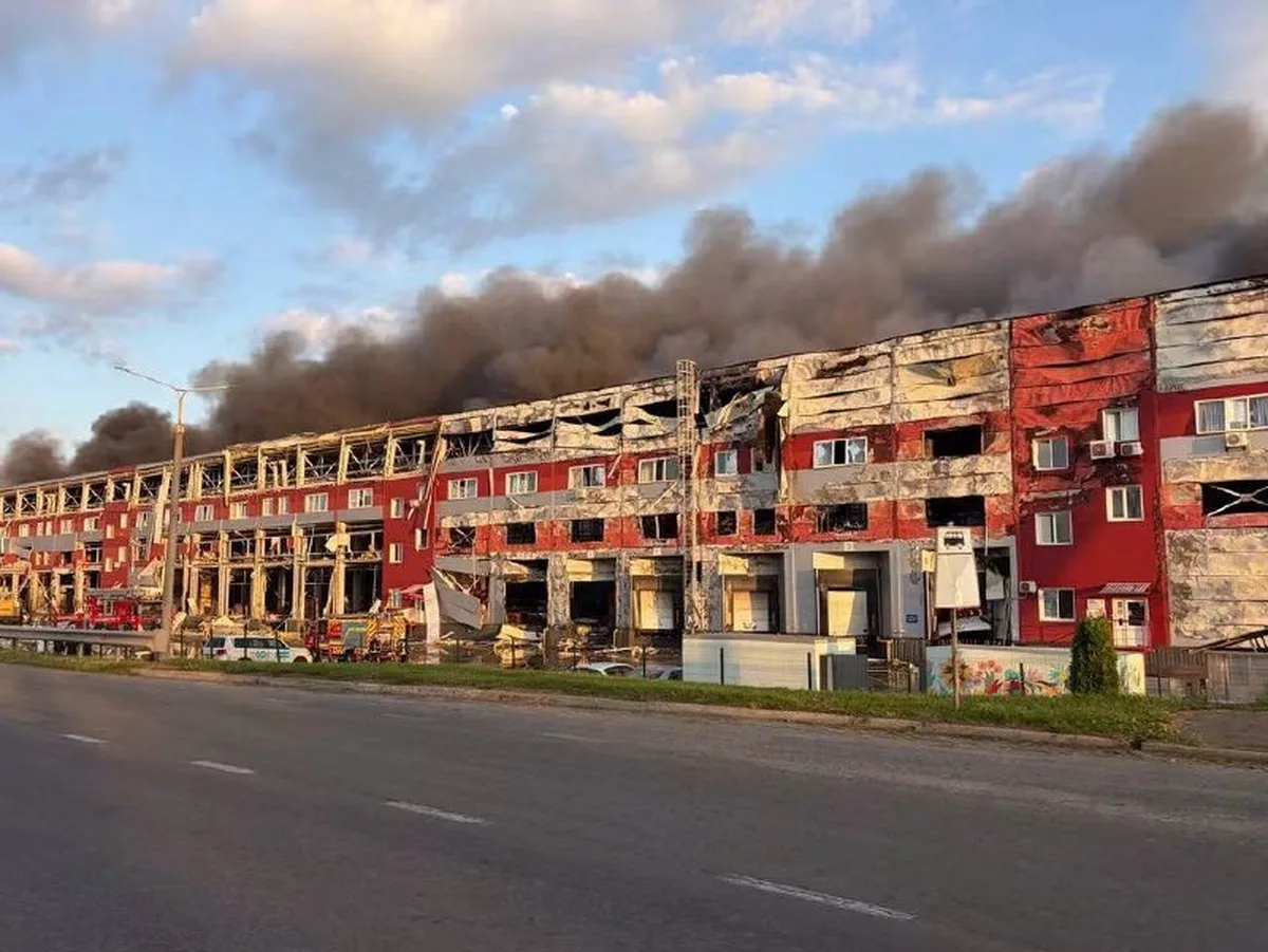 Пошкоджена багатоповерхова будівля з димом у небі