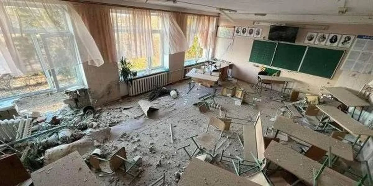 Пошкоджена класна кімната зі зруйнованою меблями та обломками