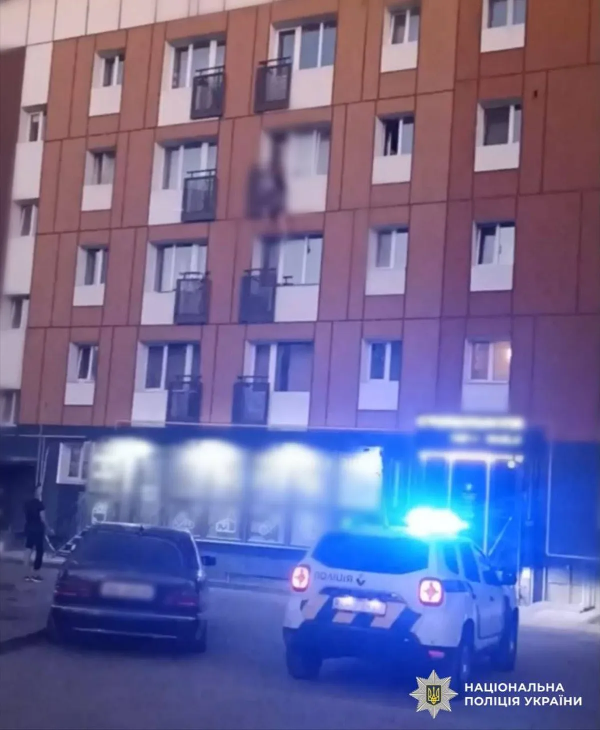 Поліцейські автомобілі біля багатоповерхового будинку