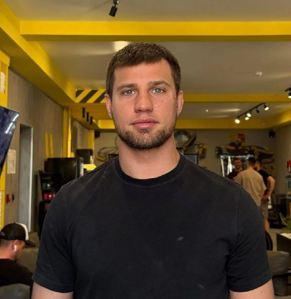 Чоловік у чорній футболці в приміщенні