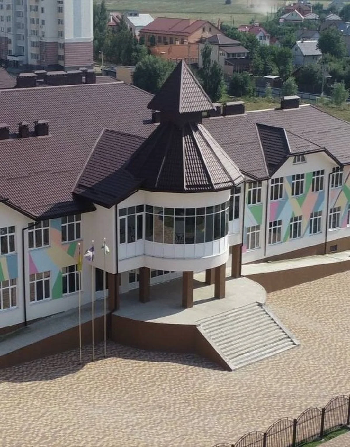 Недобудована школа з характерною вежею та пустим подвір'ям