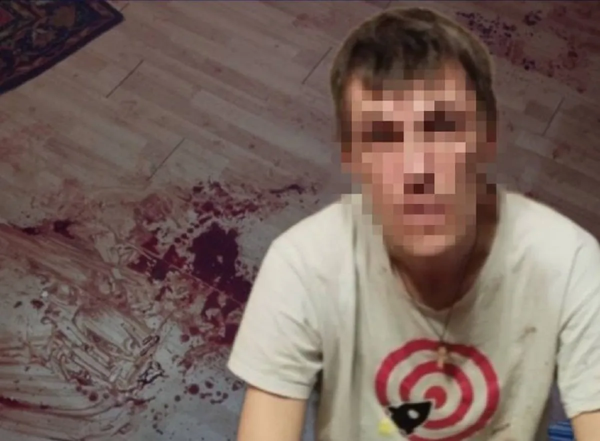 Чоловік у світлій футболці сидить на підлозі