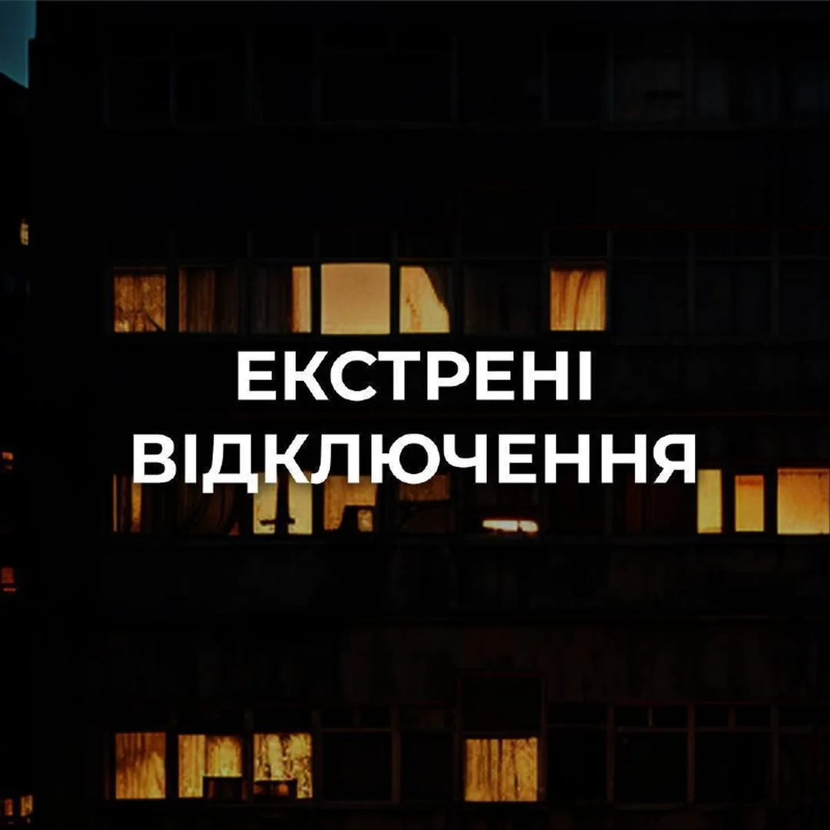 Будівля з освітленими вікнами вночі під час відключення електроенергії