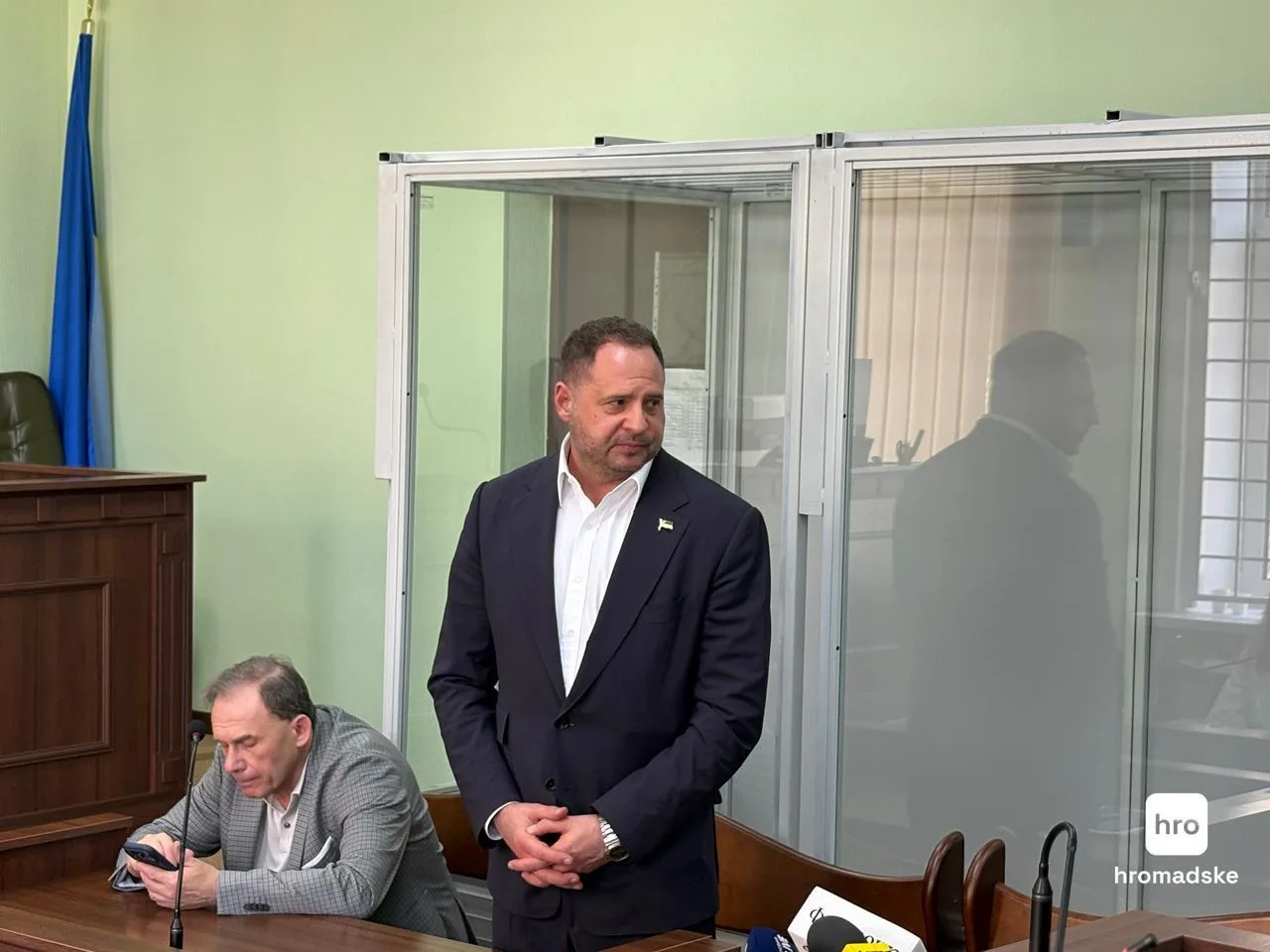 Чоловік у костюмі стоїть у залі суду