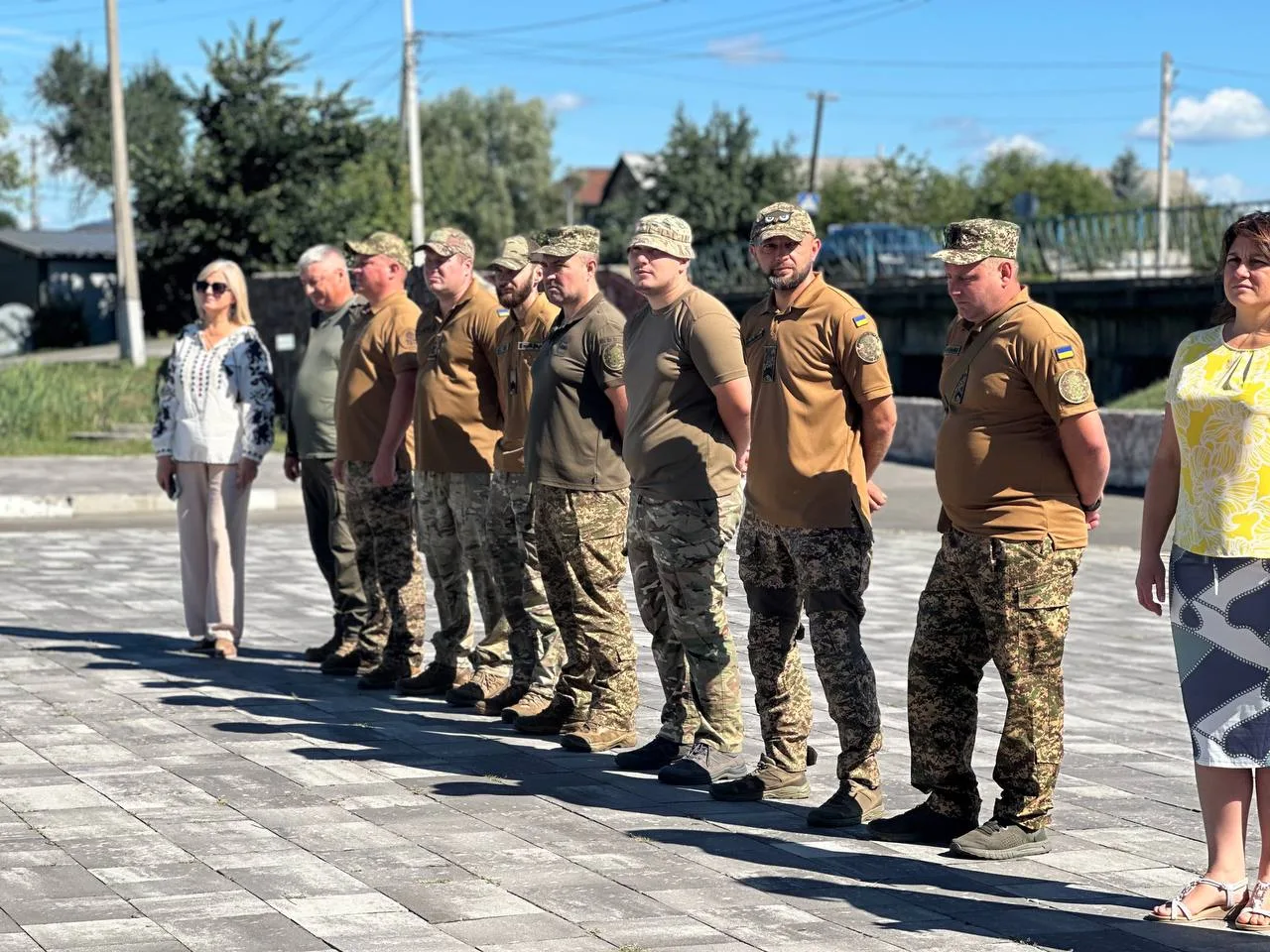 Група військовослужбовців у камуфляжі стоїть на площі