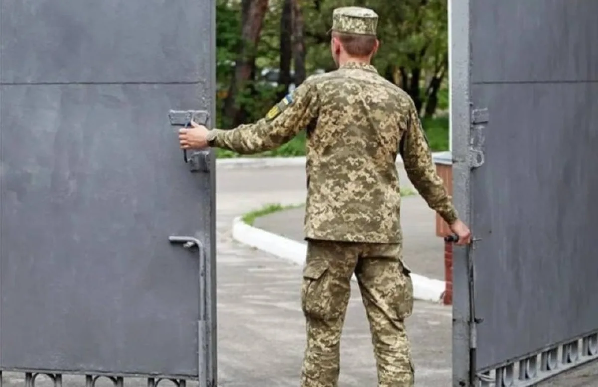 Військовослужбовець у камуфляжній формі біля воріт