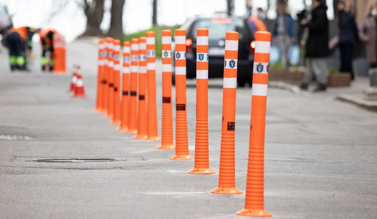 Помаранчеві пластикові стовпчики на тротуарі в ряд