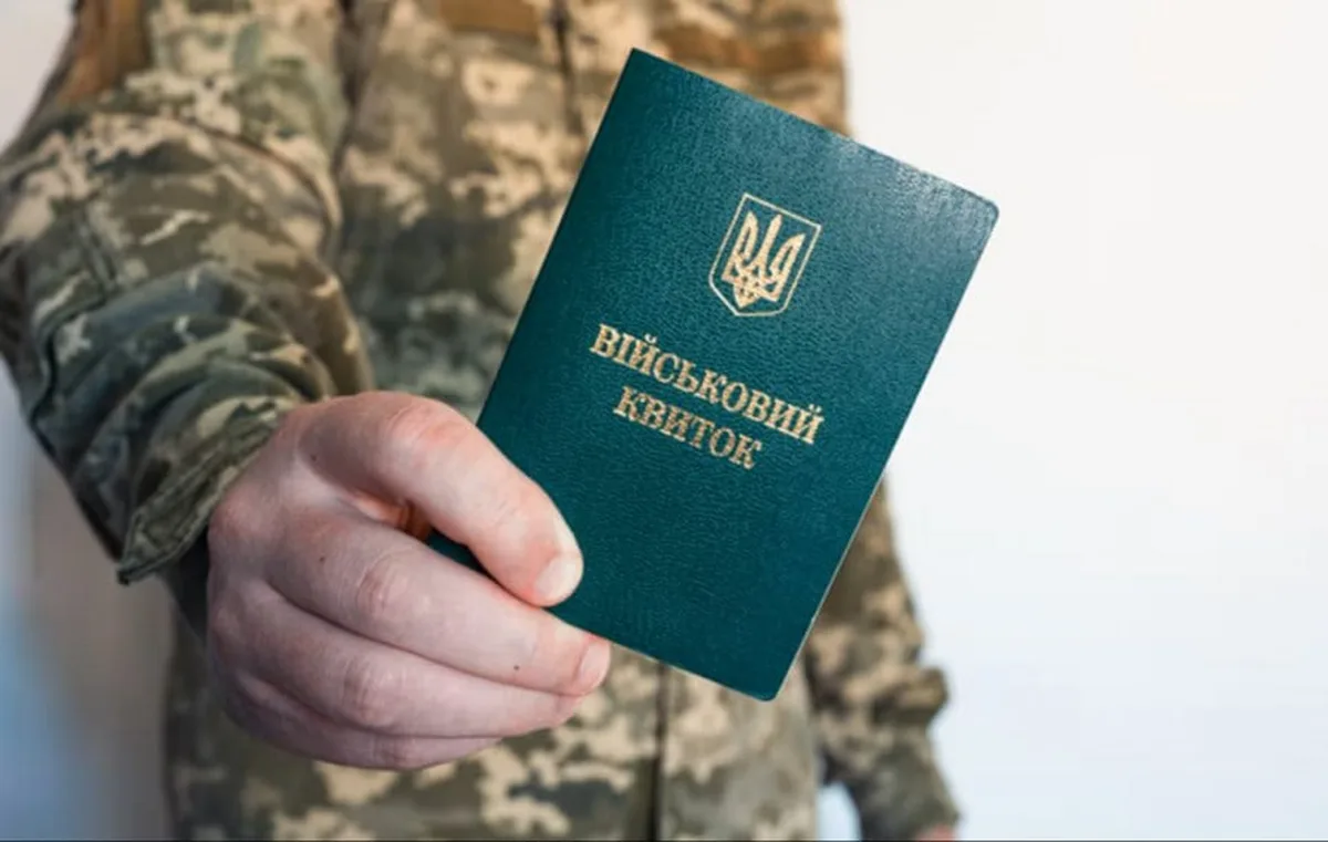 Військовослужбовець тримає військовий квиток у руці