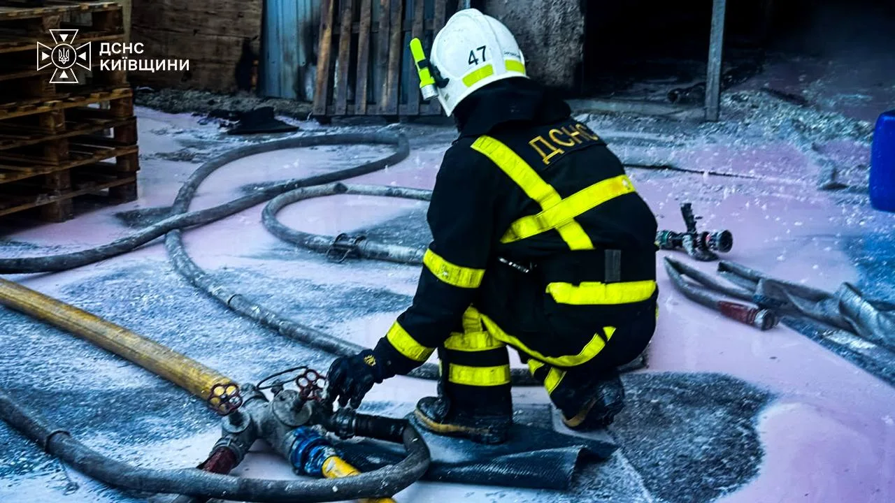 Рятувальник у спецодязі працює з пожежними шлангами