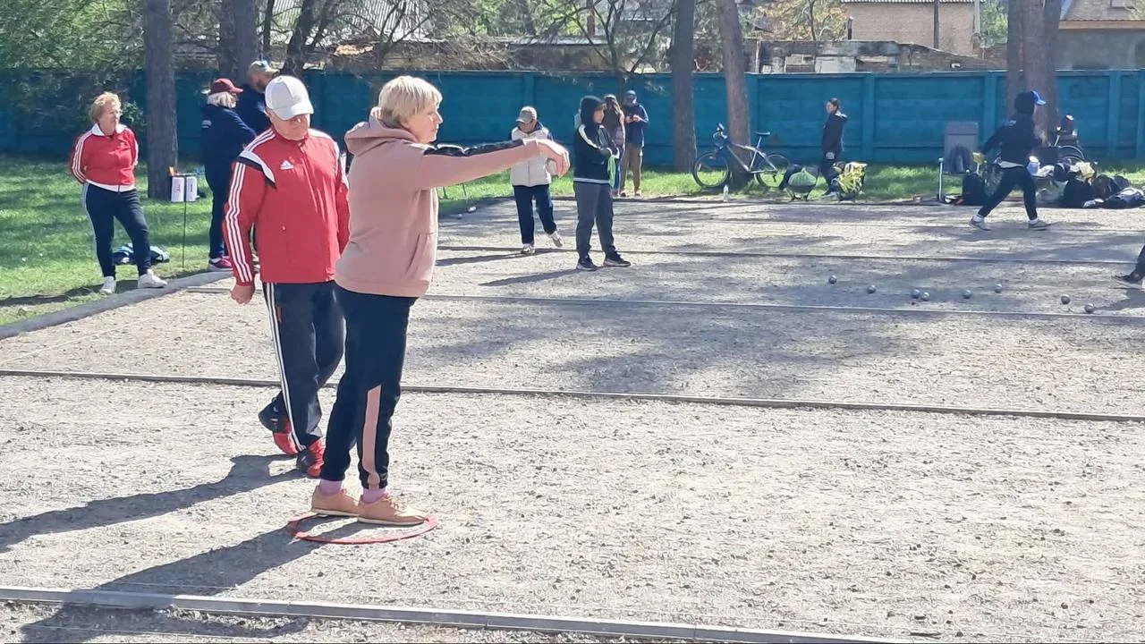 Люди грають у петанк на спортивному майданчику
