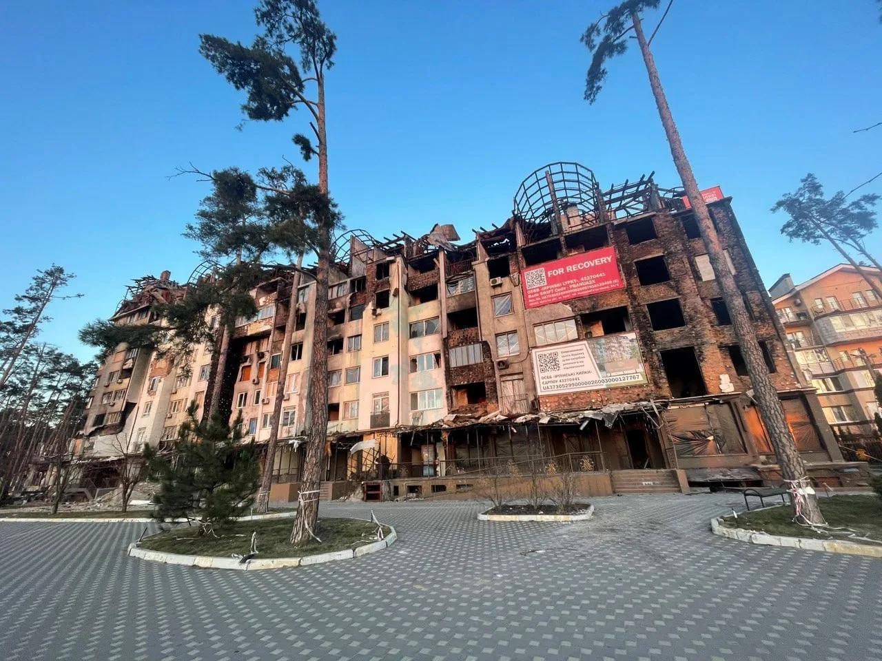 Пошкоджена багатоповерхова будівля з вибитими вікнами та отворами