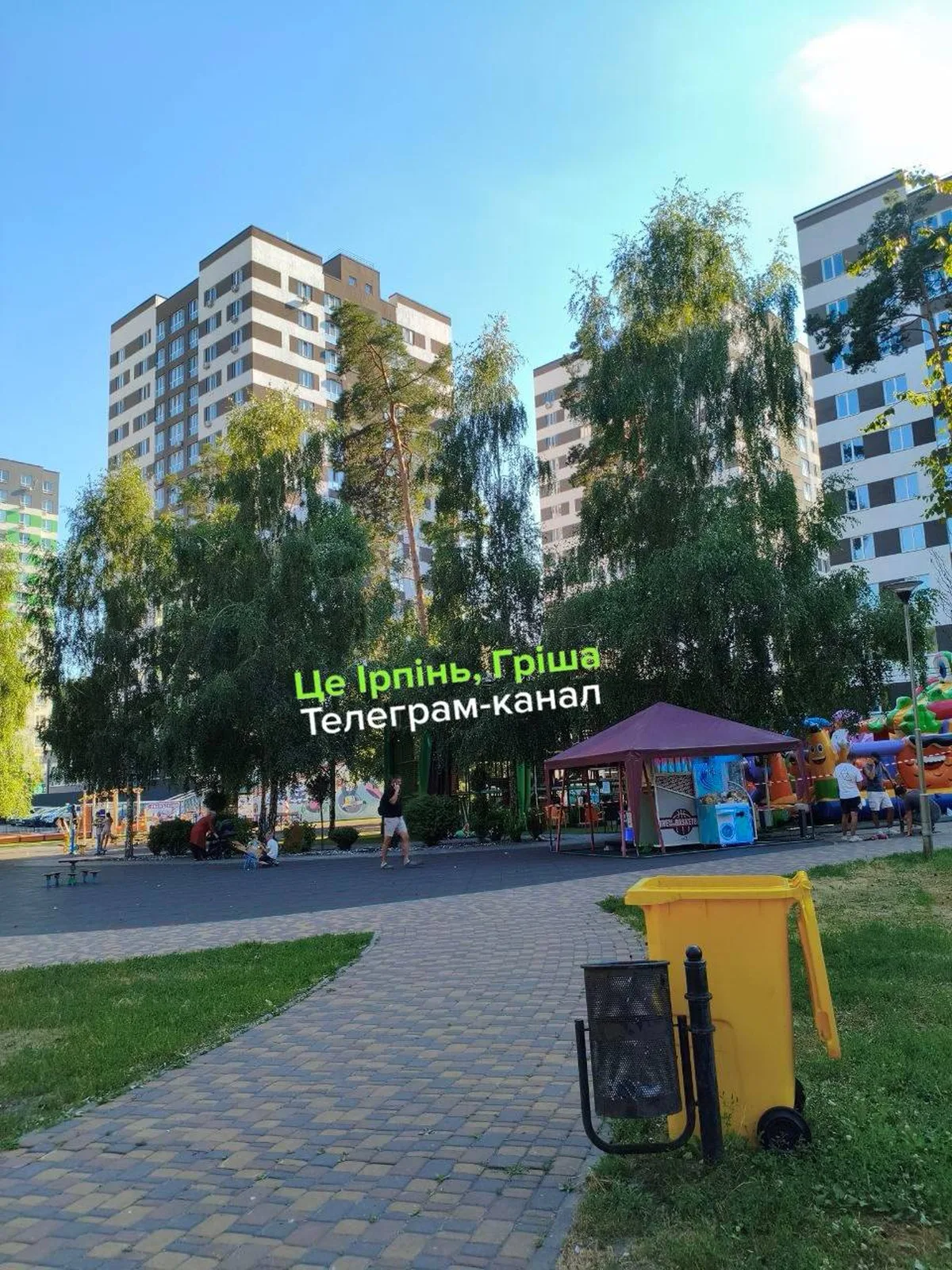 Центральний парк Ірпеня з багатоповерховими будинками та жовтим ігровим автоматом