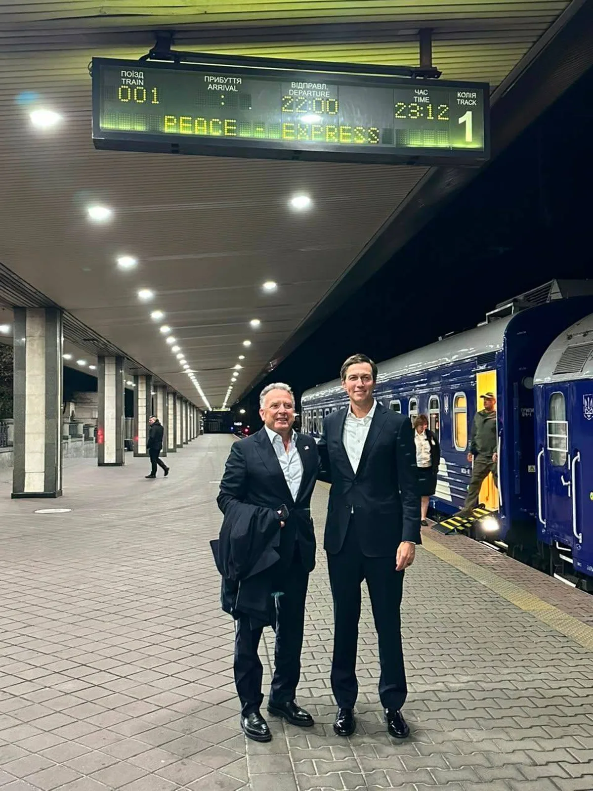 Два чоловіки в костюмах на платформі метро