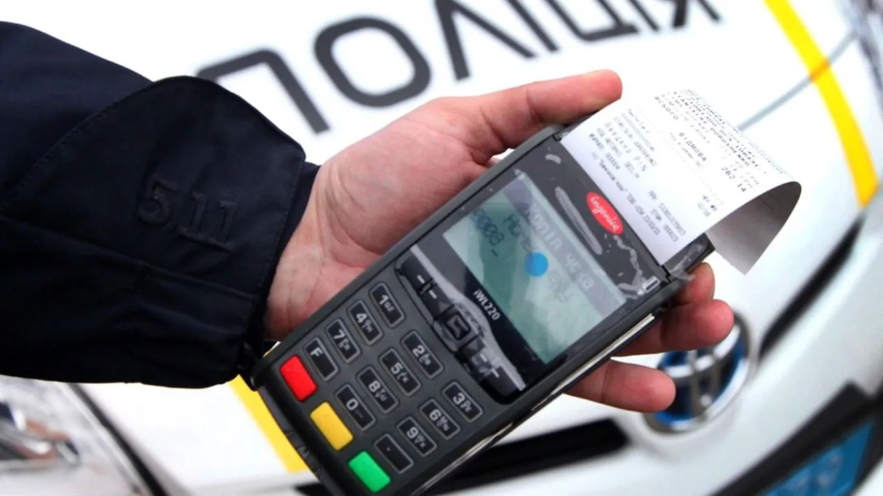 Поліцейський тримає термінал для безконтактної оплати штрафів