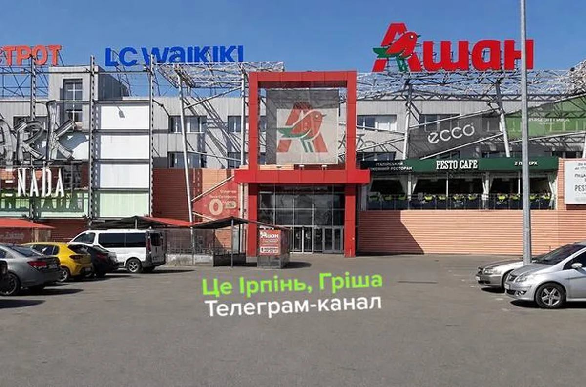 Торговий центр з вивісками магазинів на паркінгу в Ірпені
