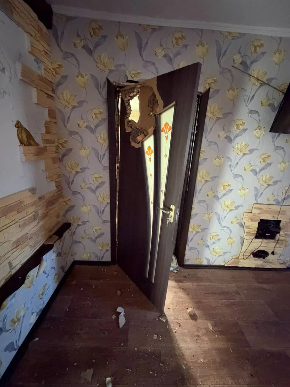 Пошкоджена кімната з відкритими дверима та пошкодженими стінами