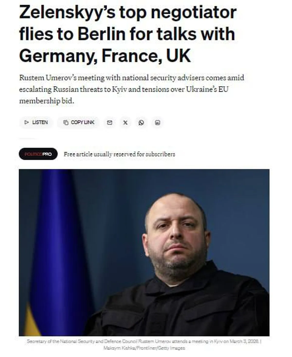 Чоловік у чорному одязі біля прапора України