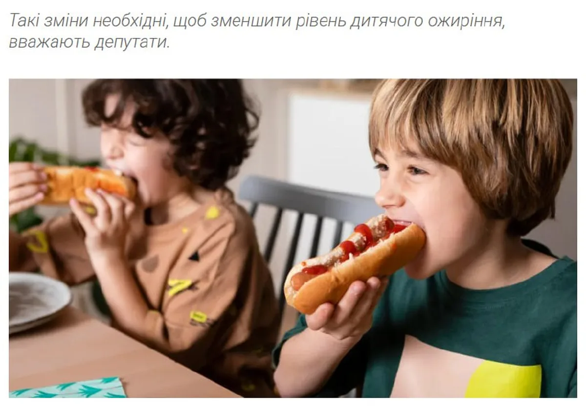Двоє дітей їдять хот-доги за столом